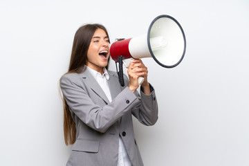 Young business woman over isolated white background shouting through a megaphone