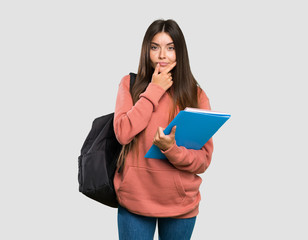 Young student woman holding notebooks thinking over isolated grey background