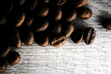 closeup coffee beans on light wood background texture.