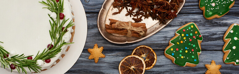 top view of christmas pie, spices and christmas tree cookies on dark wooden table