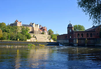 Ancient mill with a view over the Saale river to the castle in Bernburg, Germany