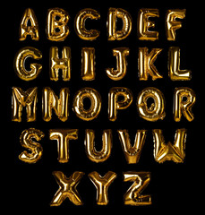 Set with golden foil balloons in shape of letters on black background