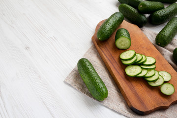 Fresh mini baby cucumbers on a rustic wooden board, low angle view. Space for text.
