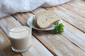 Grain white bread with parsley and glass of ayran on wooden rustic table 