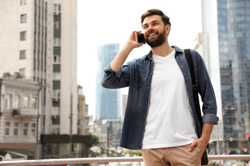Handsome man talking on phone in modern city
