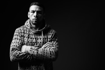 Young muscular Hispanic man against black background