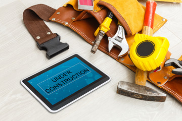Tablet and tools with home under construction concept