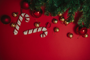 Christmas ornaments on the red background. Christmas decorations with space for text. Candy canes and balls. Christmas card.