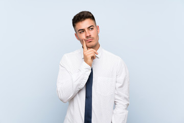 Handsome businessman over isolated blue background thinking an idea