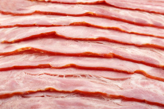 Slices of raw bacon as background, closeup