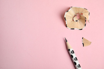 Color pencil and shavings on pink background, top view. Space for text