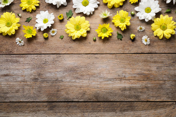 Beautiful chamomile flowers on wooden background, flat lay. Space for text