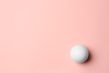 Golf ball on pink background, top view. Space for text
