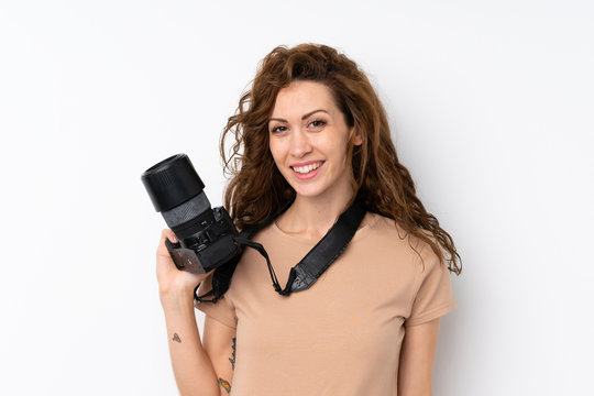 Young pretty woman over isolated background with a professional camera