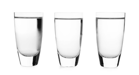 Cold vodka in shot glasses on white background