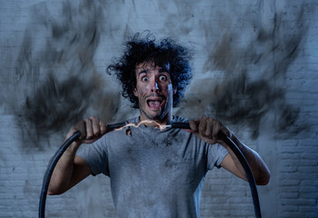 Funny image of man getting electric shock with funny face and smoke all around. DIY concept