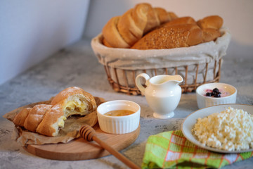 Tasty and healthy breakfast, natural cottage cheese, fresh croissant with honey. Morning still life. Bakery products.