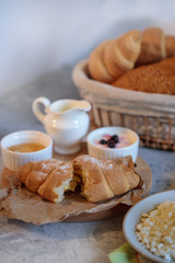 Tasty and healthy breakfast, natural cottage cheese, fresh croissant with honey. Morning still life. Bakery products.