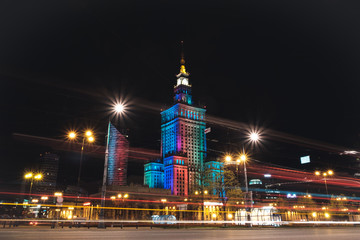 Naklejka na ściany i meble Warsaw at night, Poland. Long exposure photo of Palace of Culture and Science and downtown business skyscrapers, city center.