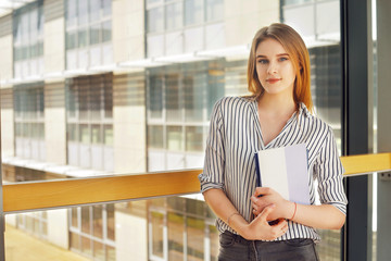 Young blonde student girl looking at camera. Woman in sunglasses in universuty. Education, training. Cool hipster student woman. Caucasian female university student looking at camera