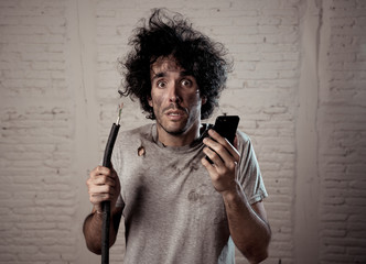 Funny man holding burnt cable calling electrician for help. DIY repairs concept