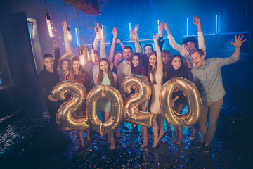 Photo of corporate party company crowd best friends holding big air balloons 2020 numbers counting last seconds to newyear wear formal wear luxury dresses shirts pants in night club