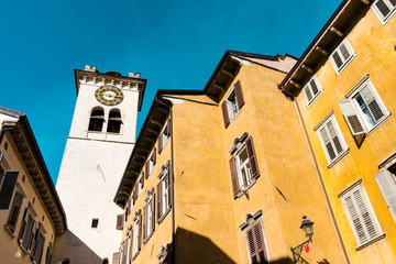 Fototapeta na wymiar Colorful houses and tower with clock in Rovereto, Italy