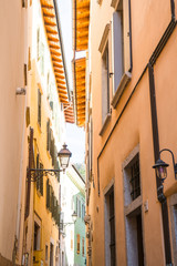 Fototapeta na wymiar Small alley with colorful houses and lanterns in Rovereto, Italy