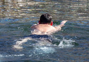 A man swims on the surface of a reservoir