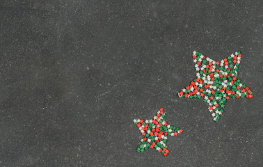  tricolor confectionery confetti in the shape of stars on a dark gray background. decor for Christmas baking.