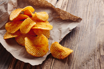 Potato chips on rustic wooden tabel.