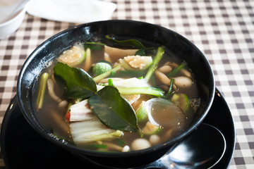 Vegetable  soup Thai food, Tom yum, Tom Zap mushroom spicy soup in black bowl.