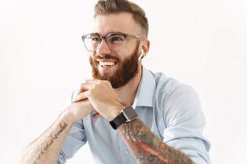 Image of unshaven young man wearing eyeglasses and wristwatch smiling