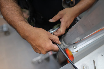 Rope access worker climbing up industrial ladder standing clipping Karabiner into first man up line permanently attached into roof safety anchor point Sydney construction site, Australia 