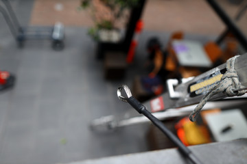 Top view picture of first man up stainless steel line permanently attached into roof safety anchor point hanging near roof ladder bracket ready to use fall protection working at height Australia 