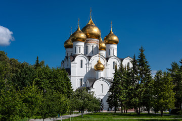 Fototapeta na wymiar Russia, Golden Ring, Yaroslavl: Famous old onion domed Virgin Mary Ascension Church Cathedral (Maria-Entschlafens-Kathedrale) in the city center of the Russian town with public park and blue sky.