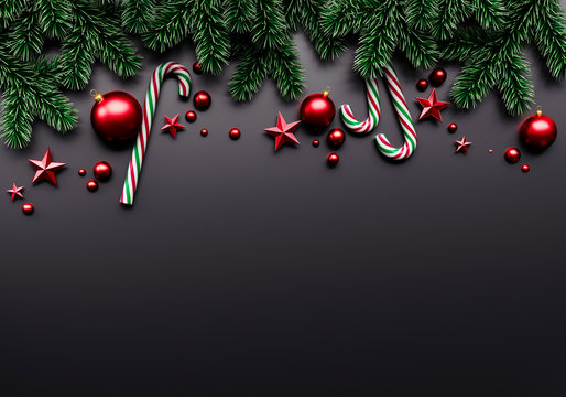 Christmas tree branches with candy sticks an red Christmas baubles on dark background 