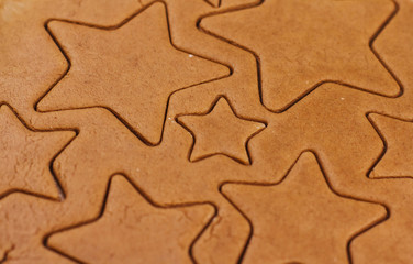 Dough for gingerbread cookies on a table. Cutting cookies in the shape of stars.	