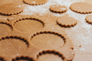  Dough for gingerbread cookies on a table sprinkled with flour. Cutting round cookies.