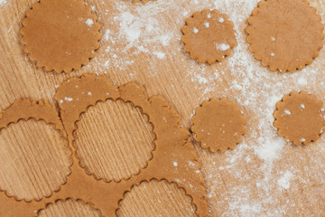  Dough for gingerbread cookies on a table sprinkled with flour. Cutting round cookies.