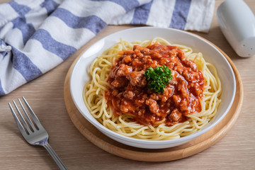 Spaghetti bolognese in white bowl.