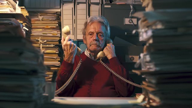 Senior office clerk answering phone calls