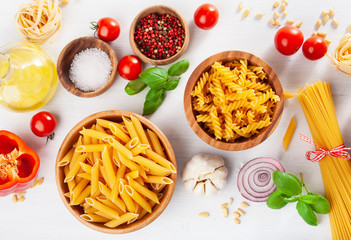 ingredients for italian cousine flat lay, pasta spaghetti penne fusilli tomato oil vegetables