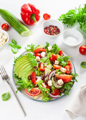 greek style avocado tomato salad with feta cheese, olives, cucumber, onion, lettuce
