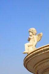 Fototapeta na wymiar Little Angel Sculpture in the Blue Sky Background