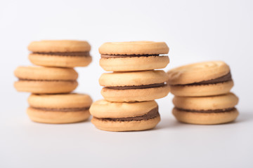 Cookies stuffed with coffee cream stacked on a white background.