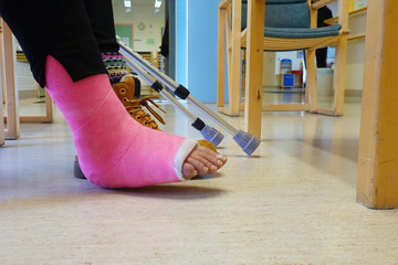 Person with orthopedic cast of foot in doctor's waiting room.