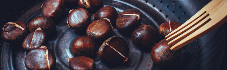 Grilled chestnuts in a pan closeup.