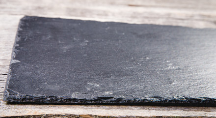 Empty Slate - Black serving platter on a wooden table outdoors.