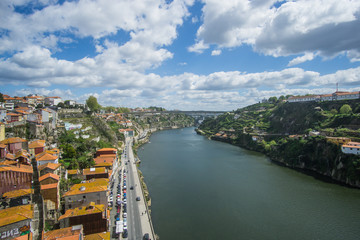 Fototapeta premium Panoramic view of Porto city , the beautiful buildings and their colorful rooftops from both sides and the douro river below , was captured from the Luís I iconic bridge Bridge